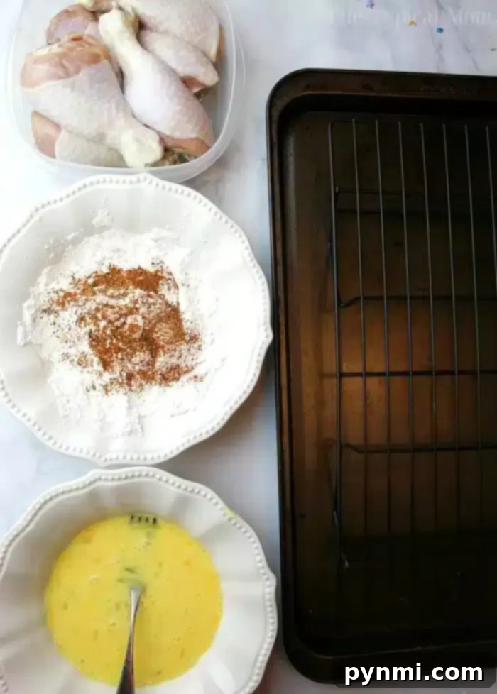Easy copycat Kentucky Fried Chicken recipe for the crispiest chicken ever. Juicy chicken drumsticks fried quickly then baked to perfection & so flavorful. #kfc #kentuckyfriedchicken #copycat #friedchicken Ingredients for Copycat Kentucky Fried Chicken: raw drumsticks, seasoned flour, beaten eggs, and an empty baking rack.