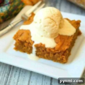 A slice of pumpkin pudding cake recipe is topped with a scoop of melting vanilla ice cream on a white plate.