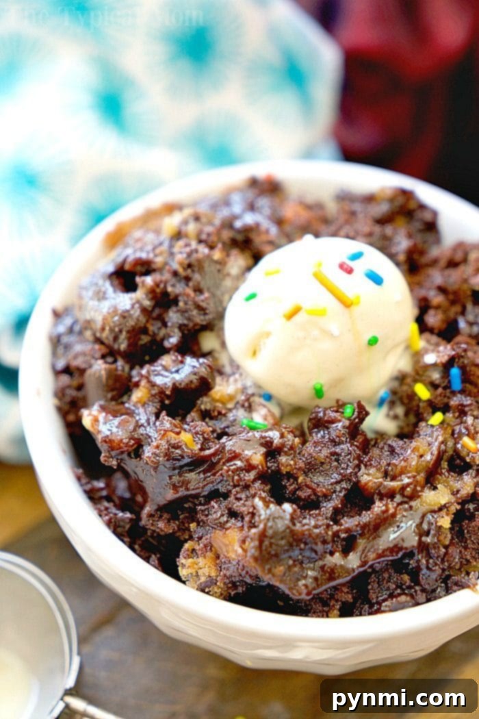 Close-up of a serving of crockpot brownie cookies with ice cream, showcasing the gooey center and crispy edges. Easy slow cooker dessert for parties.