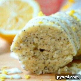 Close-up of sliced instant pot lemon poppy seed cake with glaze and lemon zest on top. Lemon slice in the background.