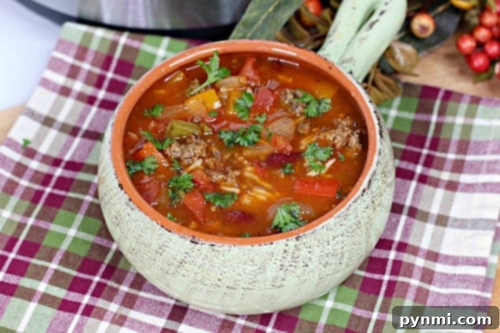 A bowl of unstuffed pepper soup with a spoon.