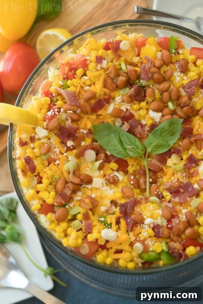 Layered cornbread salad is a perfect side dish during the holidays or a barbecue! Layers of corn, cheese and more make it irresistible! #corn #salad #layered #cornbread #sidedish Easy layered cornbread salad, perfect for holidays and barbecues