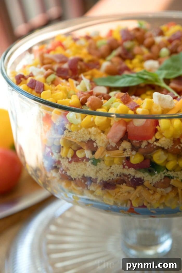 This easy layered cornbread salad recipe is a perfect side dish during the holidays or a barbecue! Layers of corn, cheese and more make it irresistible! #corn #salad #layered #cornbread #sidedish Close-up of Jiffy Layered Cornbread Salad showcasing all delicious layers