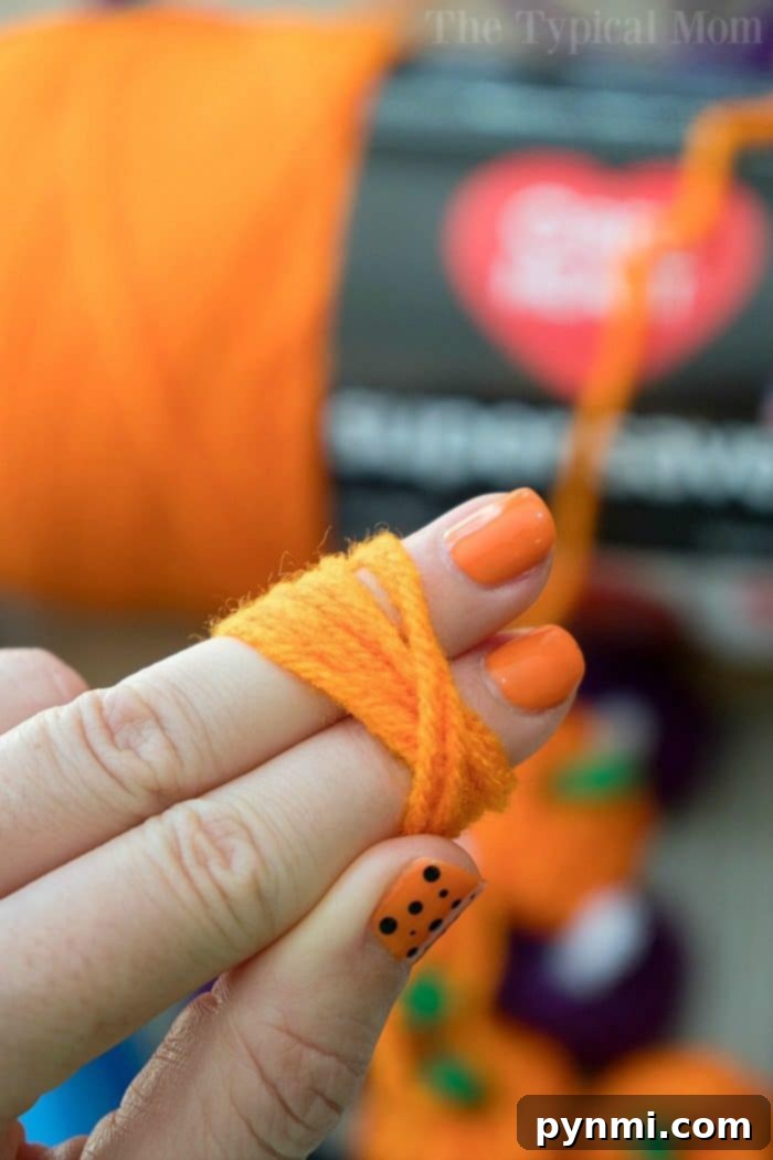 child holding yarn pumpkin craft