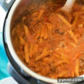 One-Pot Pressure Cooker Lasagna 5 Pasta with meat sauce being stirred with a wooden spoon inside an Instant Pot for a delicious pressure cooker lasagna casserole.