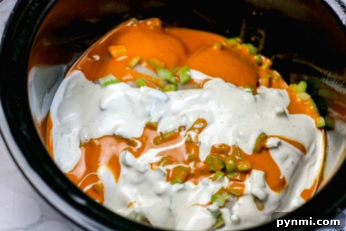 A savory buffalo chicken dip with hot sauce, ranch dressing, and green onions, perfect for sliders.