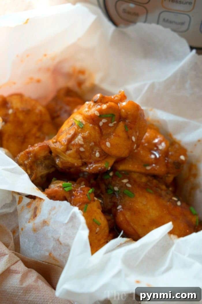 No Thawing Needed Pressure Cooker Wings 3 Instant Pot filled with frozen chicken wings coated in barbecue sauce, ready for cooking.