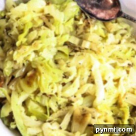 Easy Cabbage Creations 8 A bowl of cooked cabbage with a spoon, seasoned with black pepper, embodies the essence of simple cabbage recipes.