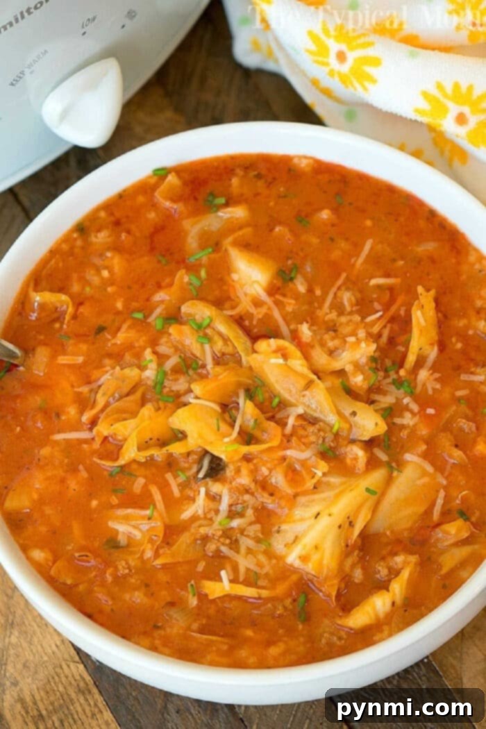 Easy slow cooker unstuffed cabbage soup with ground sausage, a hearty and flavorful crockpot meal perfect for families. A vibrant bowl of slow cooker unstuffed cabbage soup, rich with tomato broth, tender shredded cabbage, fluffy rice, and savory ground sausage, garnished with fresh herbs.