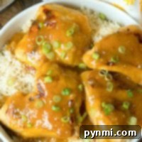 Instant Pot Honey Mustard Chicken with fresh green onions, elegantly served over rice in a pristine white bowl.