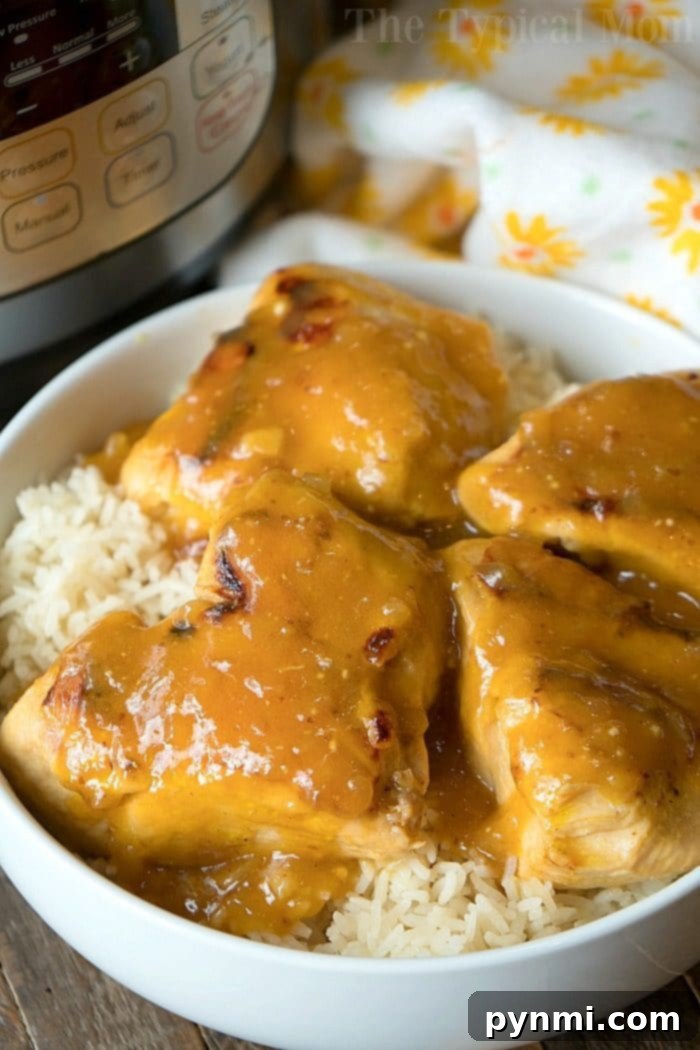A perfectly cooked Instant Pot Honey Mustard Chicken thigh, rich with sauce and garnished with fresh greens, showcased on a plate.
