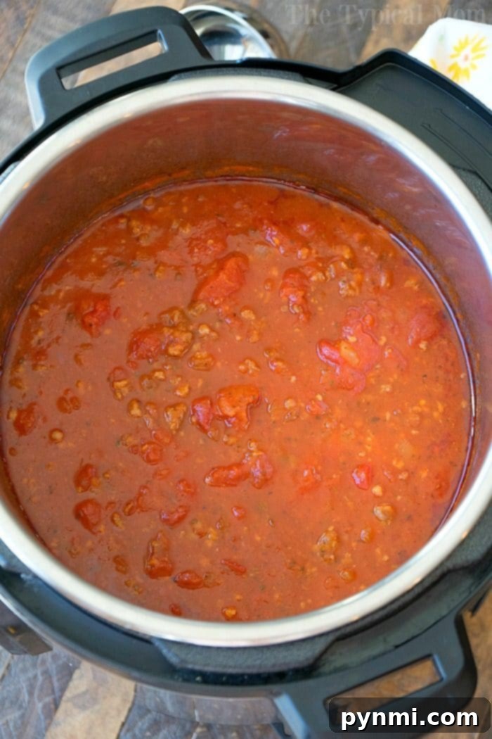 Homemade Instant Pot spaghetti sauce: better than jarred and ready quickly. An open Instant Pot reveals a hearty sauce simmering with tomatoes and ground meat, reminiscent of a robust spaghetti sauce.