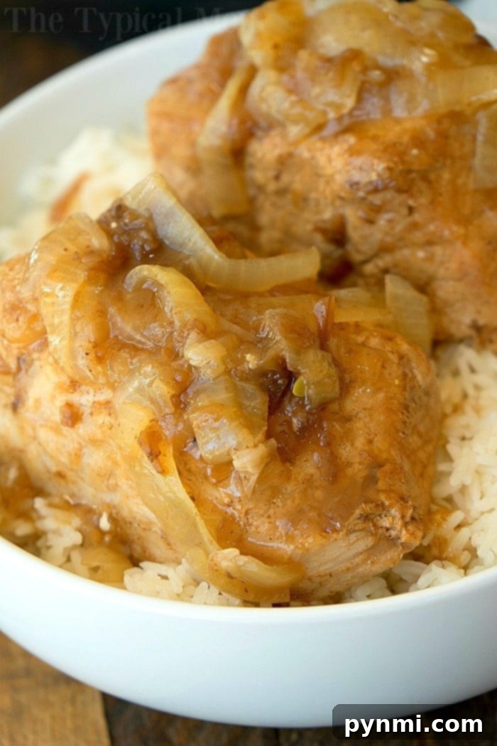 Instant Pot French Onion Pork Loin with sliced onions and gravy on a serving platter.
