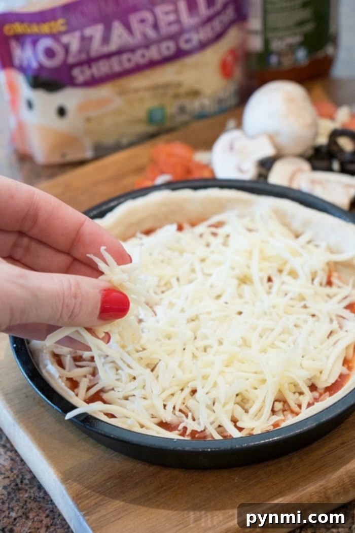 Assembling Your Instant Pot Deep Dish Pizza A freshly prepared Instant Pot pizza, bursting with mozzarella, pepperoni, and olives, sits ready to be covered and cooked, showcasing the vibrant ingredients before pressure cooking.