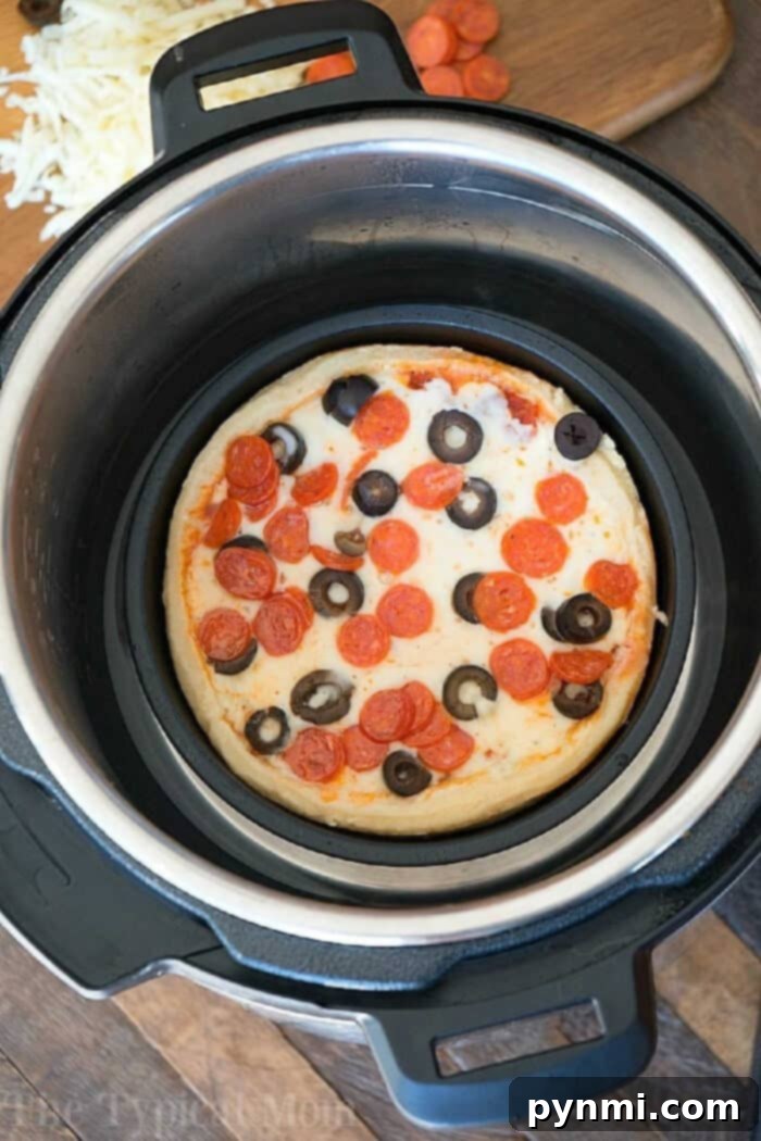 Ninja Foodi Pizza: From Pressure Cooked Perfection to Crispy Finish A close-up of a personal-sized pepperoni and olive pizza baking to perfection inside an Instant Pot, with a cutting board full of fresh, vibrant toppings like olives and cheese awaiting their turn.
