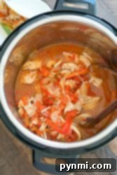 Zesty Instant Pot Salsa Chicken 5 Salsa chicken soup, featuring shredded chicken, vibrant vegetables, and a rich broth, served on a rustic wooden table.