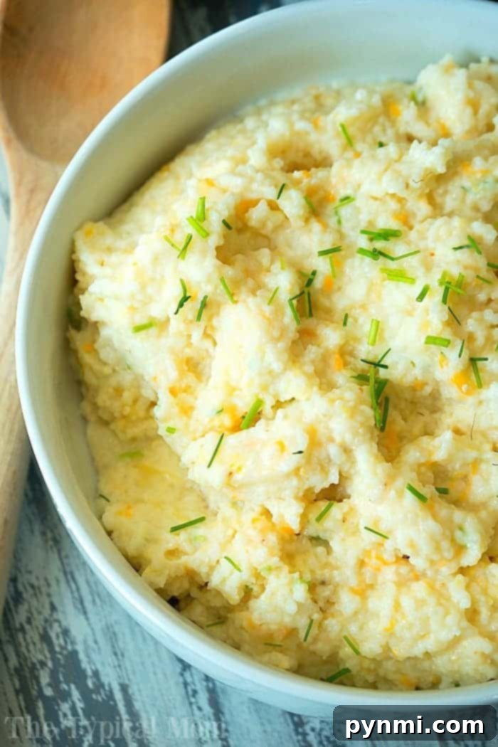 A bowl of creamy grits garnished with chopped chives sits invitingly alongside a wooden spoon. Nearby, Instant Pot grits offer a cozy pairing, perfect for any comforting meal.