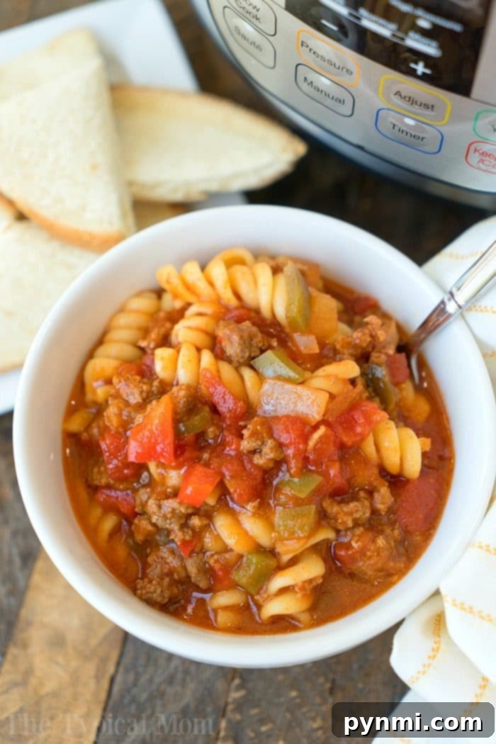 Delicious and easy Instant Pot Sloppy Joe Casserole: A hearty blend of pasta, seasoned ground beef, and tangy sloppy joe sauce, cooked efficiently in a pressure cooker, perfect for busy weeknights. #sloppyjoes #casserole #instantpot #pressurecooker #groundbeef #instantpotrecipes #thetypicalmom Close-up view of Instant Pot Sloppy Joe Casserole, showcasing perfectly cooked rotini pasta, rich ground meat sauce, and colorful bell peppers, ready for serving.