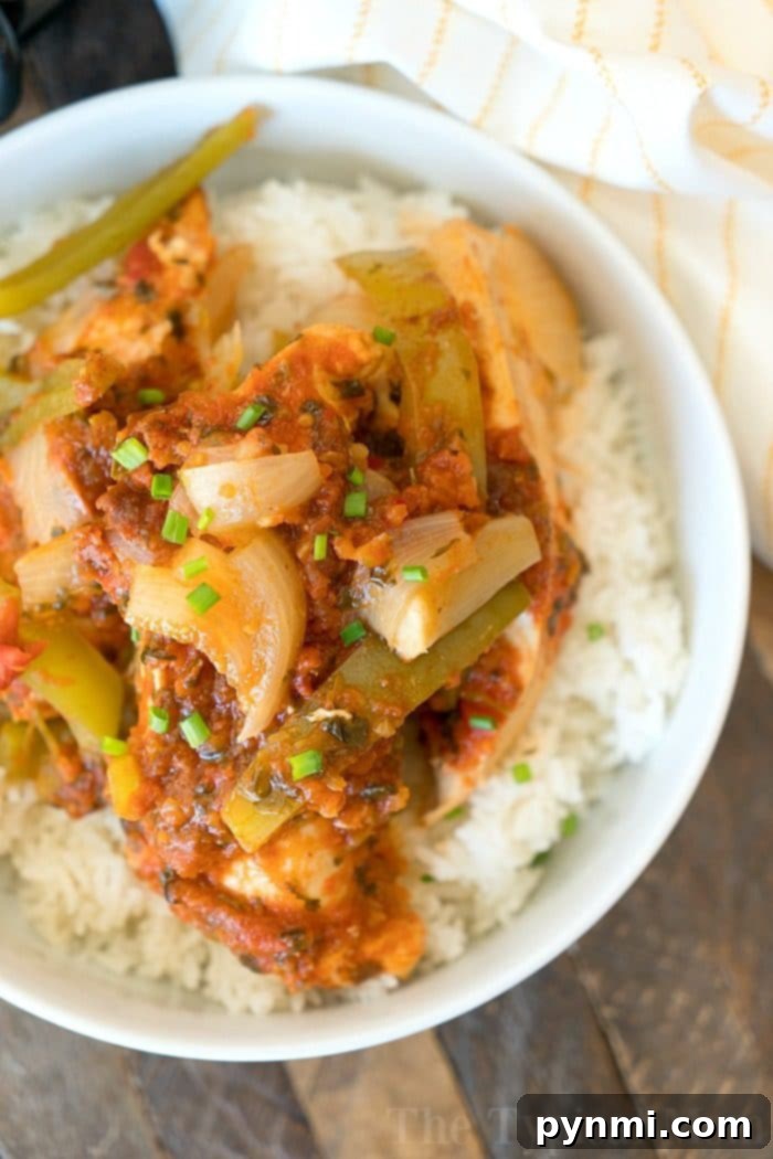 Slow cooker Salsa Chicken: easy, healthy, and versatile for any meal. A close-up shot of cooked salsa chicken in a slow cooker, ready for shredding. The vibrant colors of salsa and vegetables are visible.