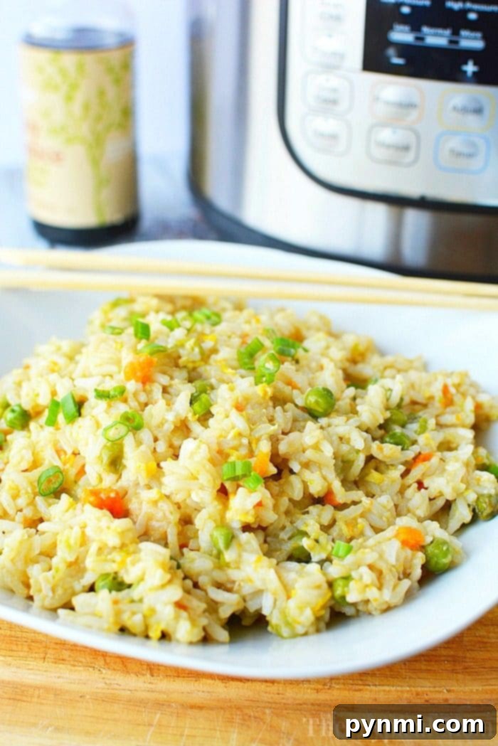 Delicious Instant Pot fried rice bursting with vegetables and rich flavor, perfect as a side or main dish. Pressure Cooker Fried Rice with mixed vegetables and egg, served on a plate with chopsticks.