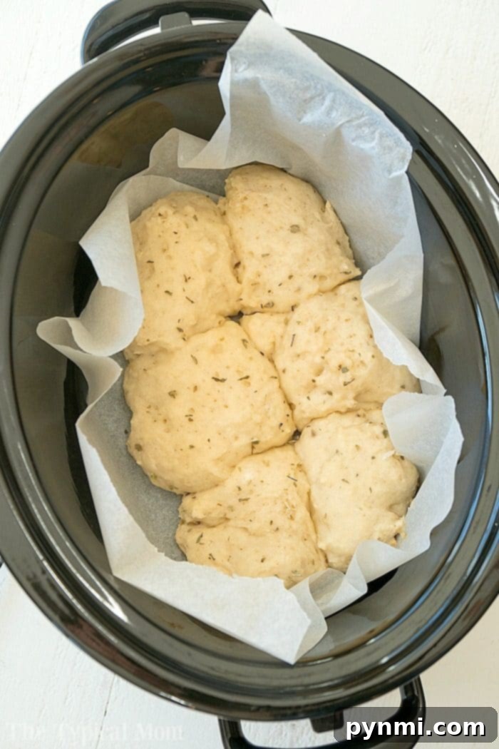 Close-up of delicious slow cooker no yeast rolls with a generous garlic-butter-parmesan topping, ready to be pulled apart.