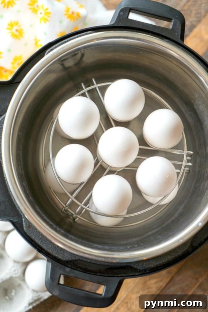 White eggs neatly arranged on a metal rack inside an Instant Pot, the perfect setup for making hard-boiled eggs effortlessly.