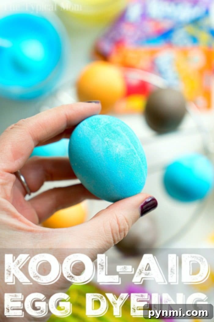 Close-up of three vibrantly dyed Kool Aid eggs in blue, orange, and red