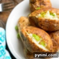 The best way to make baked potatoes is to serve them topped with chopped green onions on a white plate, resting perfectly on a wooden table.