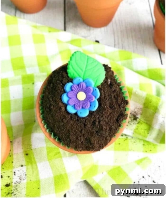 Beautifully decorated flower pot cupcakes with various edible flowers and chocolate soil.