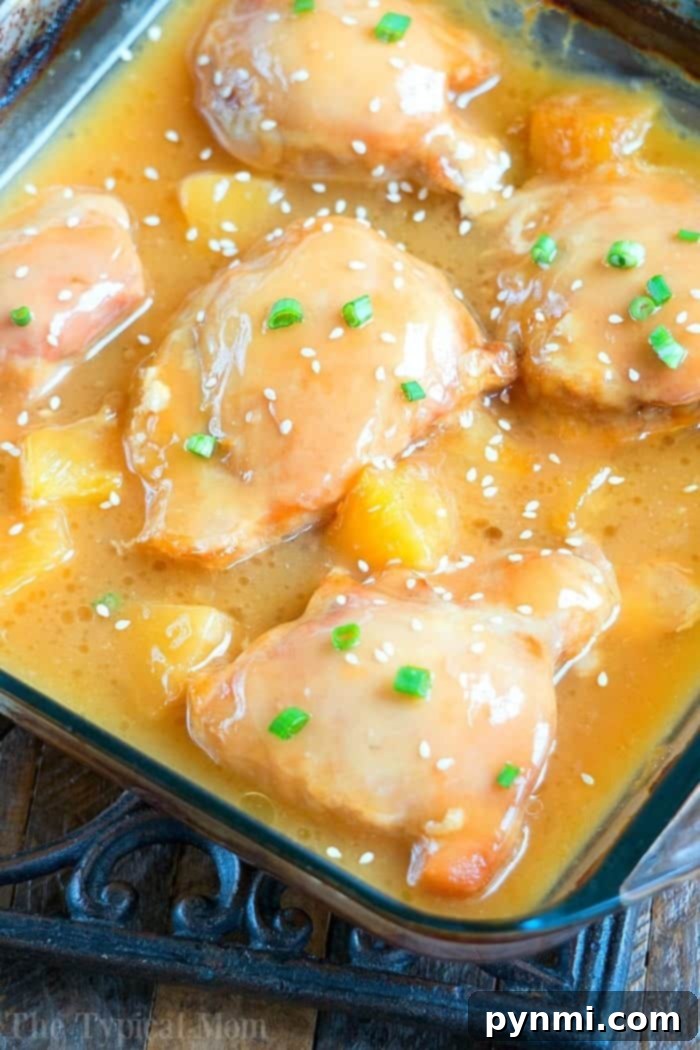 Here is an easy pineapple chicken recipe using chicken thighs that comes out sweet and really tender. Served over rice it's one of our favorite easy chicken recipes with a pineapple flavor and chunks that bring a subtle tropical flavor to your dinner. If you're looking for something different to serve, give this a try. #pineapple #chicken #easy #dinner #chickenthighs #baked Close-up of tender pineapple chicken with a rich glaze