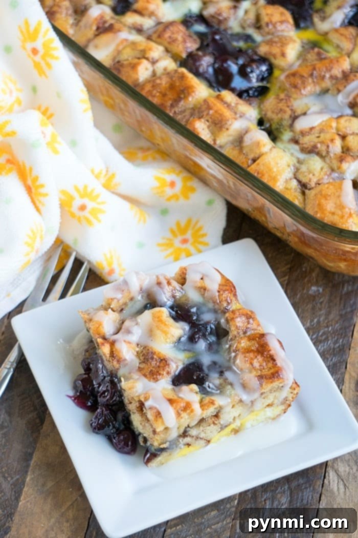 This easy cinnamon roll breakfast casserole with blueberries is just amazing! Served for brunch or on Christmas morning it is a great way to make cinnamon rolls into a fruit casserole that everyone will love. Feeds 12 and costs under $10 to make which is a winner in my book! #cinnamonroll #casserole #breakfast #blueberry #fruit #easy Cinnamon Roll Breakfast Casserole with frosting