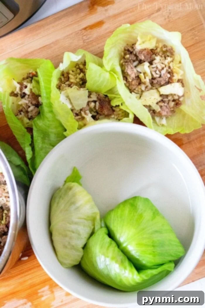 Delicious Instant Pot stuffed cabbage rolls filled with ground beef, rice, and cheese, cooked quickly in a pressure cooker. A perfect family dinner! #instantpot #instantpotrecipes #stuffedcabbage #cabbage Instant Pot Stuffed Cabbage rolls topped with sauce in a dish