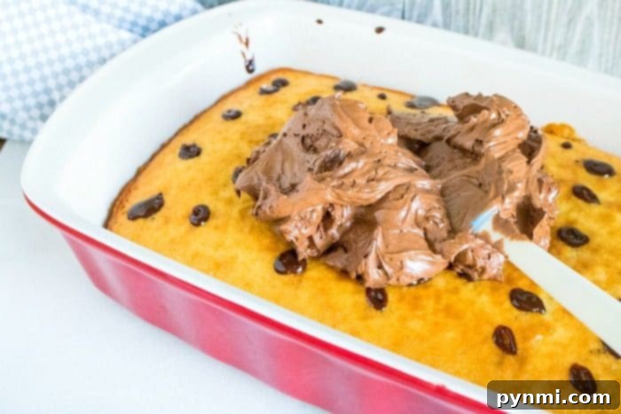 how to make a poke cake 2 - A freshly baked sheet cake with numerous holes visible on its surface, ready for the delicious filling to be poured in.