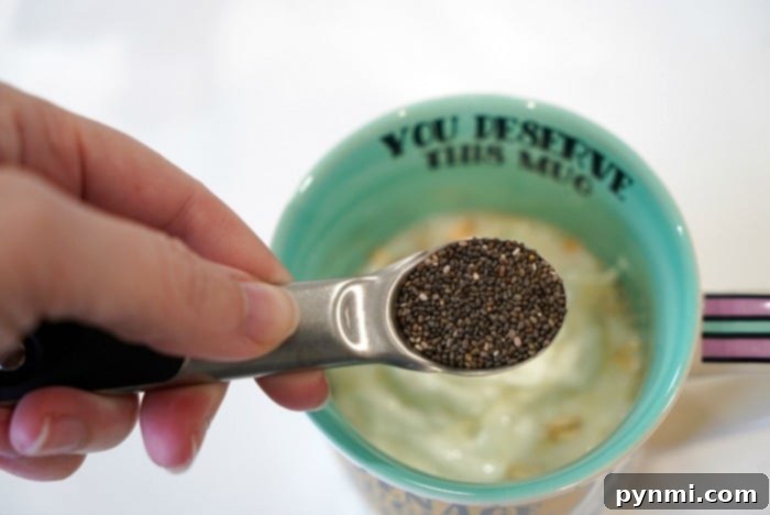 A glass cup filled with creamy chia seed yogurt or pudding, ready to be topped.