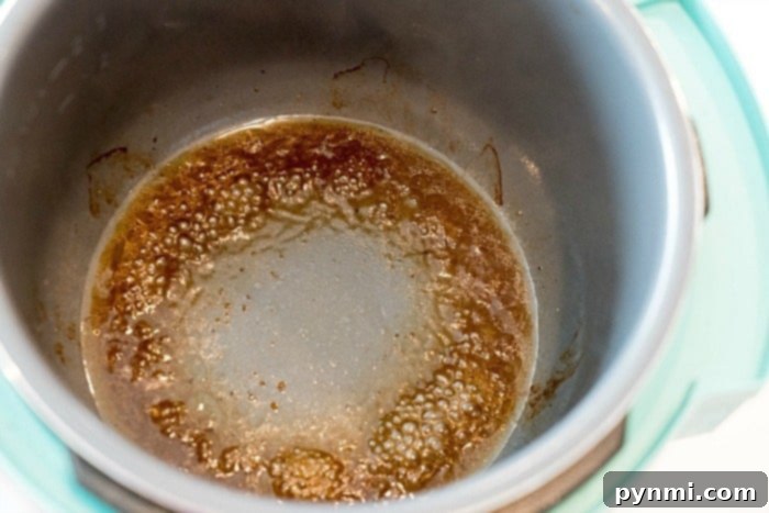 Troubleshoot Instant Pot Burn Notice 3 Chef's hand deglazing a pot with liquid to remove stuck food
