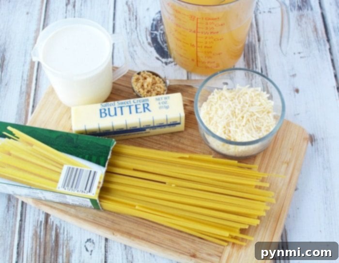 This Instant Pot fettuccine alfredo recipe is easy to make and a creamy buttery dinner your whole family is sure to love. Inexpensive pressure cooker meal. #instantpot #instantpotrecipes #alfredo #fettuccinealfredo #pasta #easy Ingredients for Instant Pot Fettuccine Alfredo: uncooked pasta, butter, grated cheese, cream, and garlic on a wooden board.