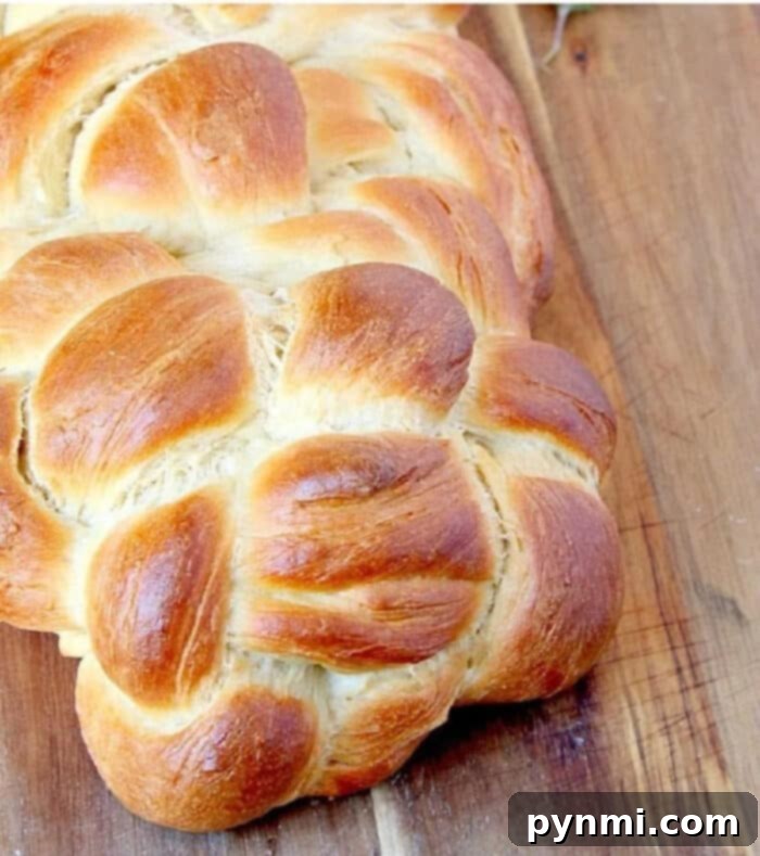 Mastering the Art of Challah Baking 2 Golden-brown, beautifully braided Challah bread on a wooden board, ready to be served