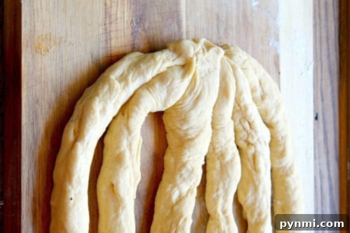 Learn how to braid Challah dough for a beautiful, homemade braided bread. Perfect for Jewish cuisine and holidays. Hands demonstrating the braiding technique for Challah dough, creating an intricate pattern