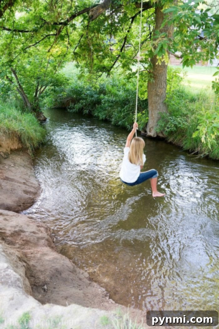 Flexible and durable kids' jeans from Abercrombie Kids, perfect for energetic outdoor play like rope swings. Girl enjoying a rope swing in flexible kids back to school jeans