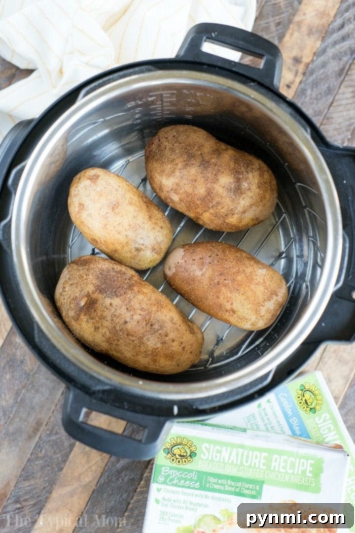Pressure cooker baked potatoes and stuffed chicken are a great duo! Instant Pot dinner success again. #pressurecooker #instantpot #bakedpotatoes #potatoes #sidedish #instantpotrecipes #thetypicalmom #ninjafoodi Pressure Cooker Baked Potatoes with crispy skins and tender insides, a perfect complement to stuffed chicken.