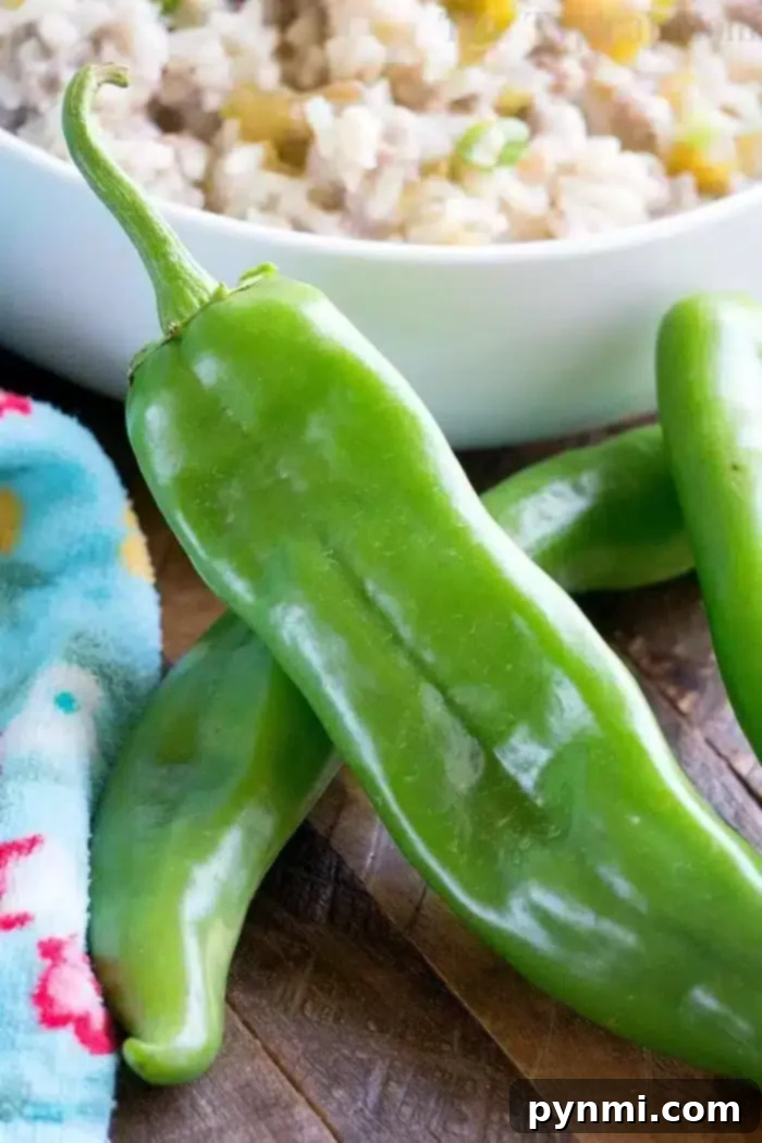 Green peppers are placed on a wooden surface next to a colorful cloth and a bowl of rice, ready to transform your meal into an instant pot sausage rice casserole.