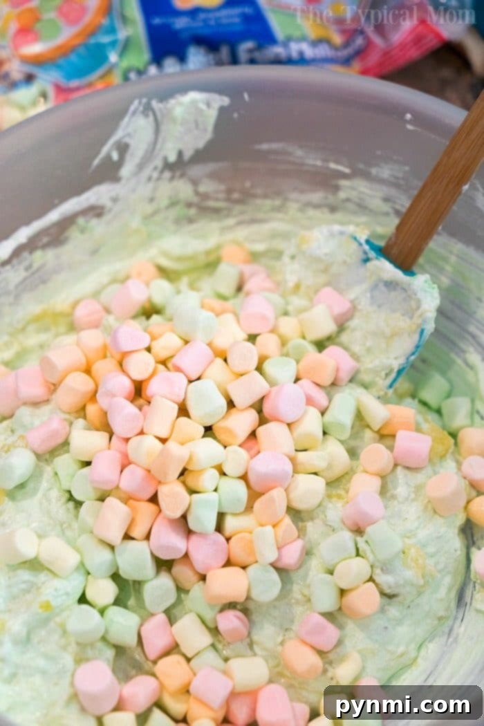 Close-up of fluffy Pistachio Pudding Ambrosia with mini marshmallows and oranges