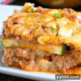 Pasta-Free Lasagna Perfection 8 A close-up of a cheesy slice of no noodle zucchini lasagna on a white plate.