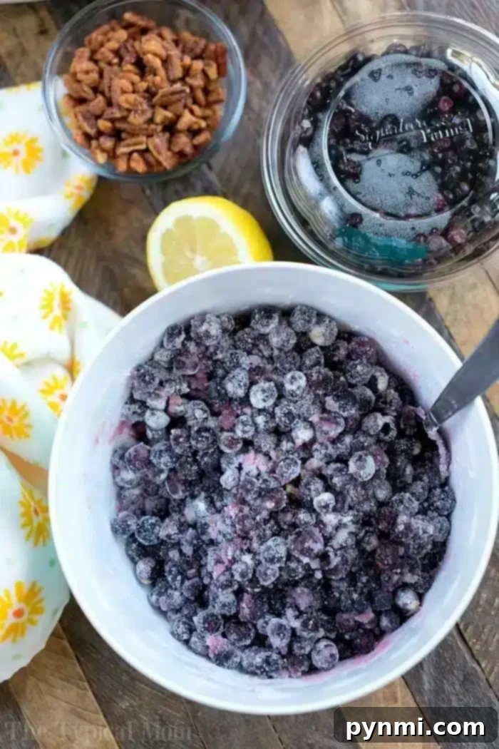 Fresh Huckleberries for Homemade Jam Fresh huckleberries, a glass jar of berries, a lemon half, and a small bowl of pecans are arranged on a yellow-patterned cloth.