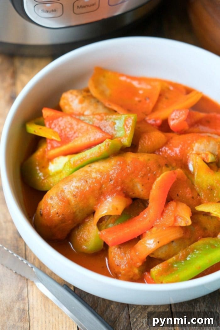 A close-up shot of a plate filled with Instant Pot sausage and peppers, demonstrating a quick and easy pressure cooker meal. The dish features tender sausage links, colorful bell peppers, and onions, all perfectly cooked and ready to be enjoyed.