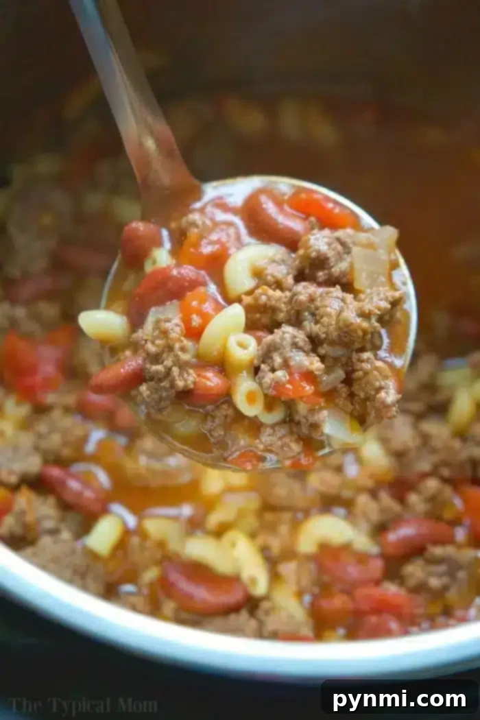 A vibrant and cheesy bowl of Instant Pot Chili Mac, featuring tender pasta, rich chili, and melted cheese, garnished with fresh green onions. This comforting one-pot meal is perfect for a quick and satisfying dinner.