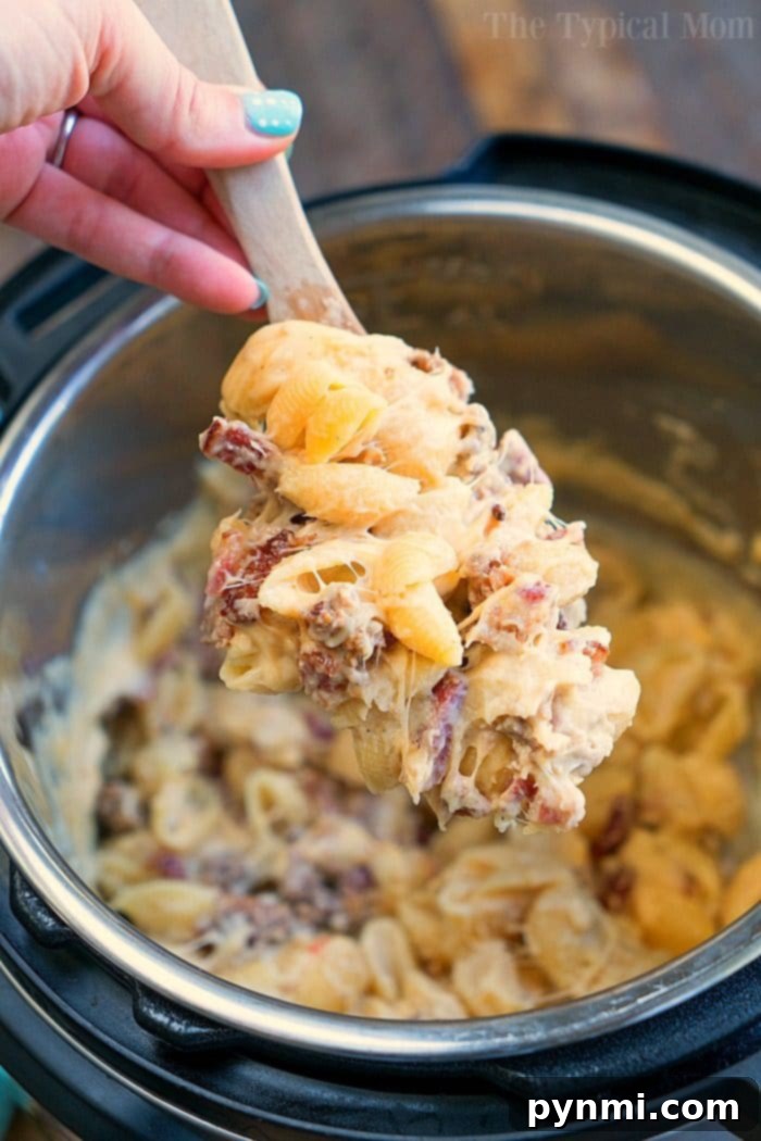 Meat lovers pressure cooker mac and cheese recipe is creamy and filled with bacon and sausage! A hearty Instant Pot dinner anyone will love for sure. #instantpotrecipes #pressurecooker #macandcheese #macaroniandcheese #meatlovers #sausage #ninjafoodi #ninjafoodirecipes #bacon #pasta #macaroni #dinner #thetypicalmom Meat Lover Pressure Cooker Mac and Cheese