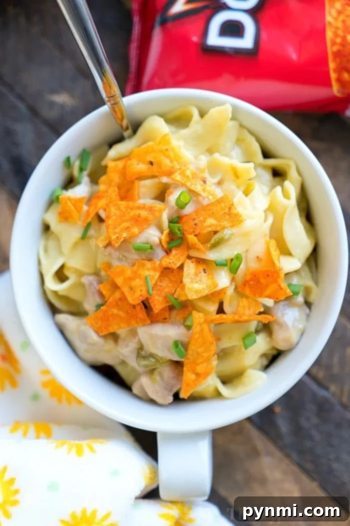 Creamy Pressure Cooker Dorito Casserole with chicken and noodles, topped with crushed Doritos and fresh herbs.