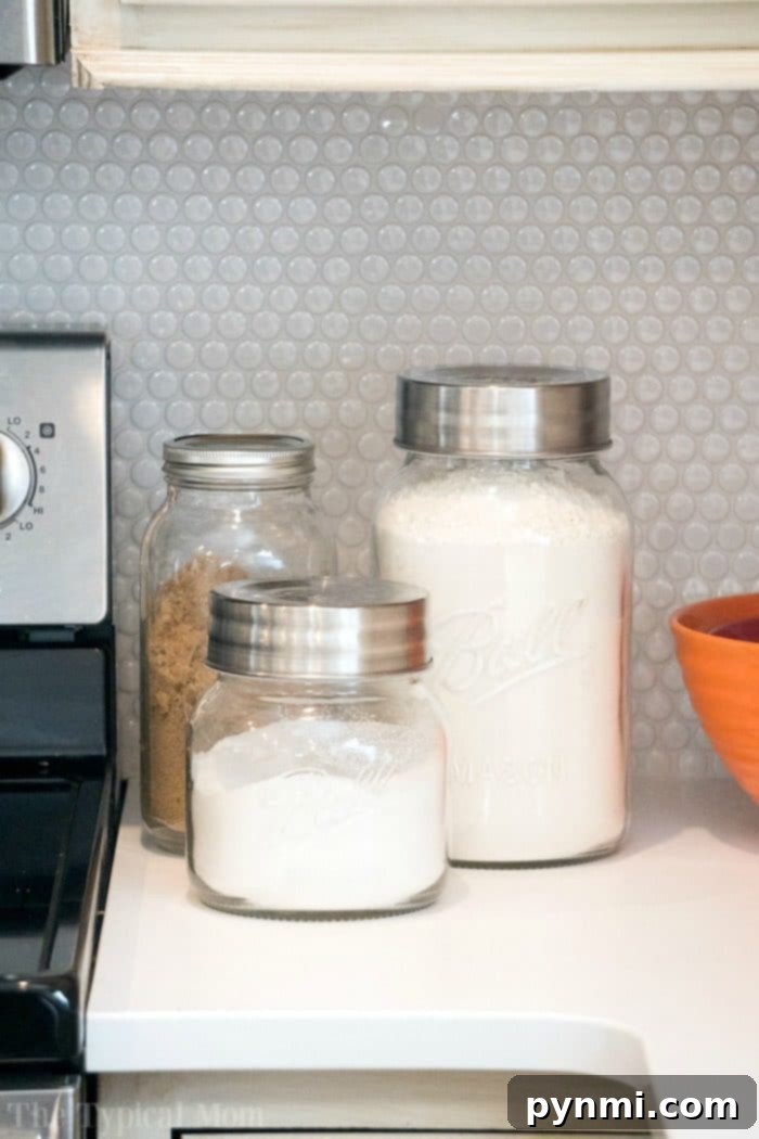Explore our transformed dark kitchen, now a bright haven with fun Farmhouse kitchen decor, including these beloved big mason jars and a barn door pantry! #farmhouse #decor #masonjar #barndoor #decorating #kitchen #table #lights #chairs Big Mason Jars for Kitchen Storage