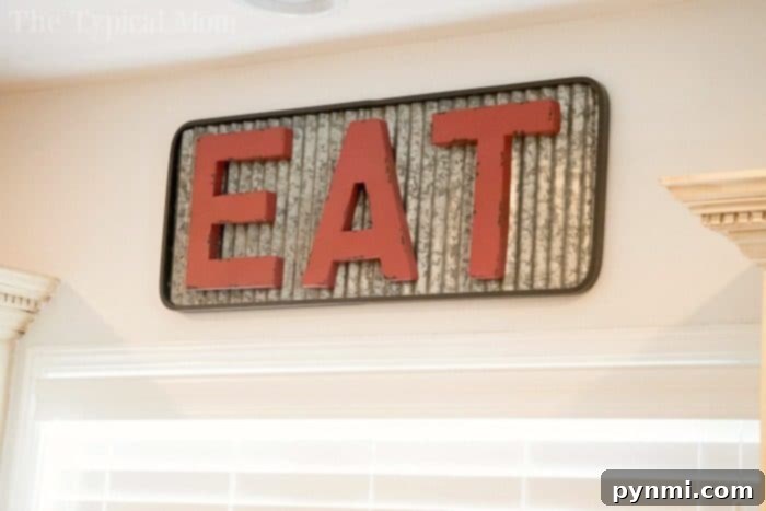See how we transformed our dark kitchen into a bright room with fun Farmhouse kitchen decor, including this charming eat sign, and a barn door pantry everyone loves! #farmhouse #decor #masonjar #barndoor #decorating #kitchen #table #lights #chairs Eat Sign for Farmhouse Kitchen Decor